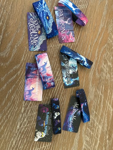 Reviewer's six unique bands from the Winter Wonders Collection laid out on a wooden surface, showing off the colorful designs.