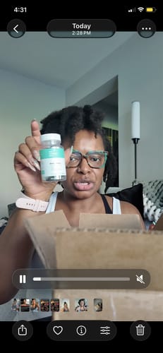 Reviewer holding up a bottle of Body Magic Chlorophyll Pills during a video review while unboxing.