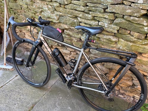 Customer's bicycle parked against a stone wall, which they track using the SPOTMINDERS. Tracking Card.