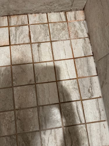 Customer's tiled floor with orange, dirty grout before using the Bathroom Concentrate 4x.