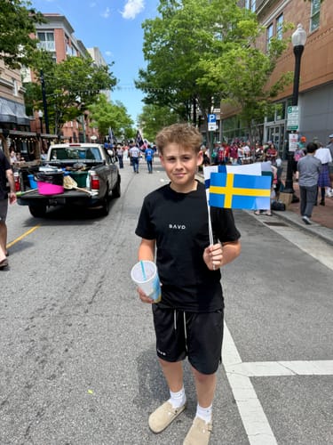 Reviewer's son wearing the black 'Cross Pattern' Youth Performance Shorts outdoors on a city street.