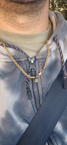 Un cliente lleva puesta la Cadena Rope Oro 4mm alrededor del cuello, sobre una sudadera con capucha.