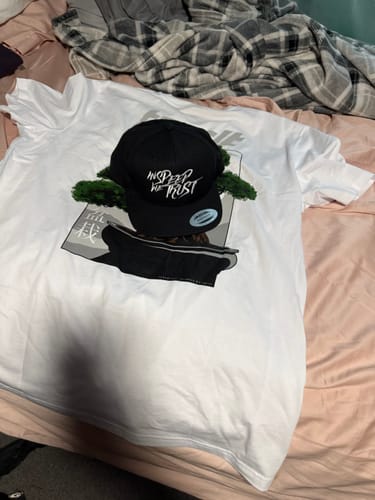 Customer's black Snap Back "Vandals" hat displayed on top of a white graphic t-shirt.