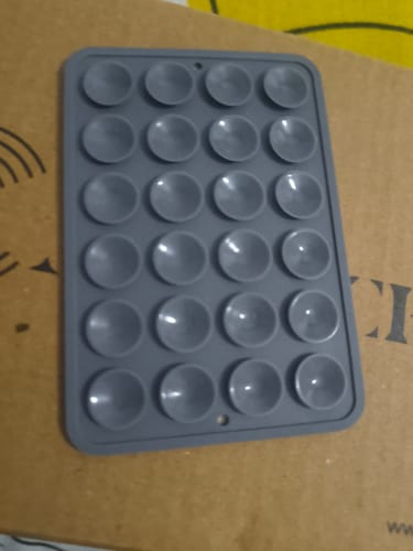 A close-up view of the reviewer's grey StickyPod, highlighting its 24 suction cups.
