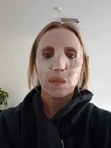 Eine Kundin trägt die Kollagen Boosting Maske auf ihrem Gesicht.