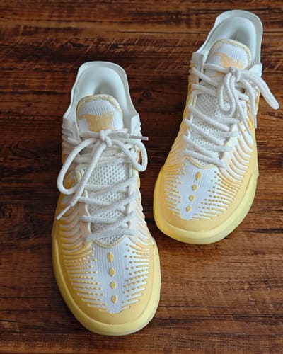 Customer's Joker 2 GT "Daybreak" shoes in white and yellow, shown from above on a wooden surface.
