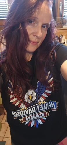 Une cliente portant le T-shirt Aigle HDC noir, avec le grand motif d'aigle coloré bien visible.