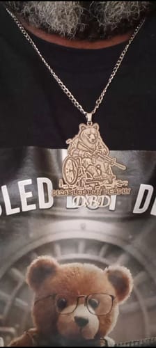Customer wearing the custom engraved photo pendant necklace. The logo shows a bear in a wheelchair holding a rifle.