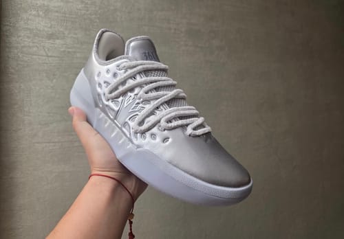 Reviewer holding the sleek silver and white Joker 2 "Arctic Flash" shoe.