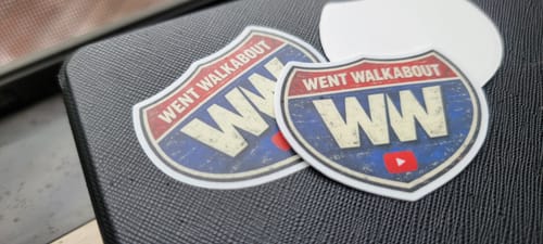 Customer's custom vinyl stickers with a distressed highway sign design, one applied and one showing the backing.