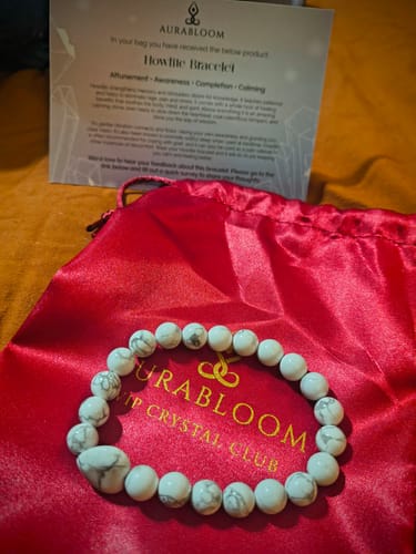 Customer's Howlite bracelet from the VIP Crystal Club, displayed on its red pouch next to a descriptive card.