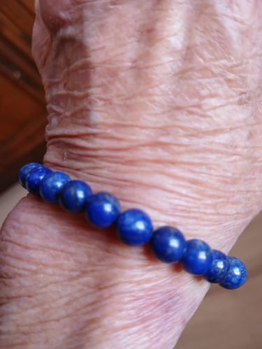 Avis d'un client : gros plan sur le bracelet Lapis Lazuli aux perles bleues, porté au poignet.