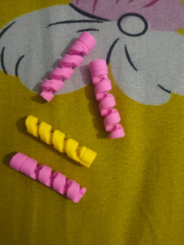 Customer's spiral Cable Protector Set in pink and yellow on a patterned surface.