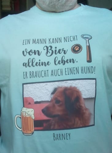 Kunde trägt das hellblaue personalisierte T-Shirt mit einem Foto seines Hundes Barney.