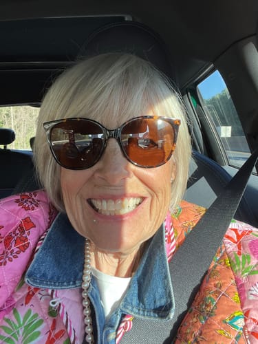 Reviewer smiling brightly while sitting in a car.