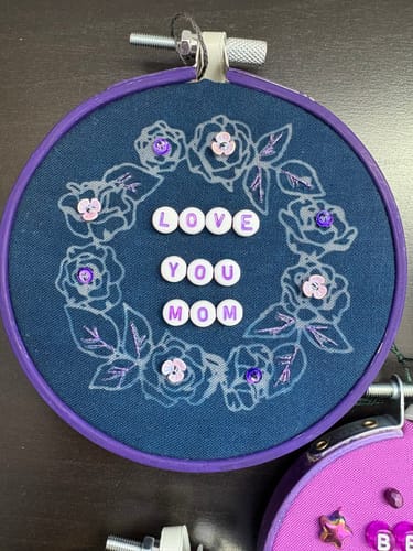 Customer's cyanotype print of a floral wreath on blue fabric, created using the decorative scrapbooking paper in a hoop.