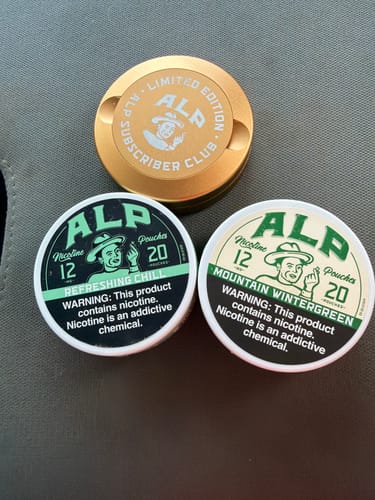 Customer's tin of Mountain Wintergreen Nicotine Pouches shown with another flavor and a gold subscriber club tin.