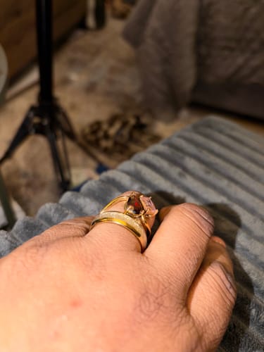 Close-up of a customer wearing the gold Navae Birthstone Ring with two different colored stones.