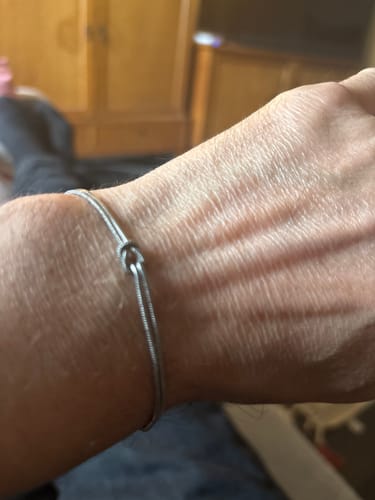 Customer wearing the silver-colored Forever Knot Bracelet on their wrist.