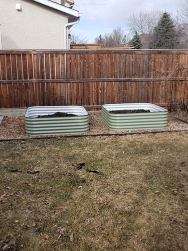 Customer's two tall modular garden beds, assembled and filled with soil, set up in a backyard.
