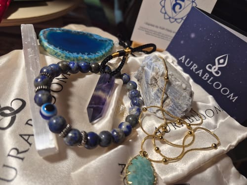 Reviewer's contents from their AuraBloom Subscription Box, showing a lapis lazuli bracelet, crystals, and an amazonite necklace.