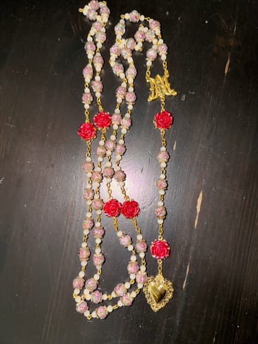 Customer's Rose Accent Devotion Rosary with pink beads and red roses laid on a dark table.