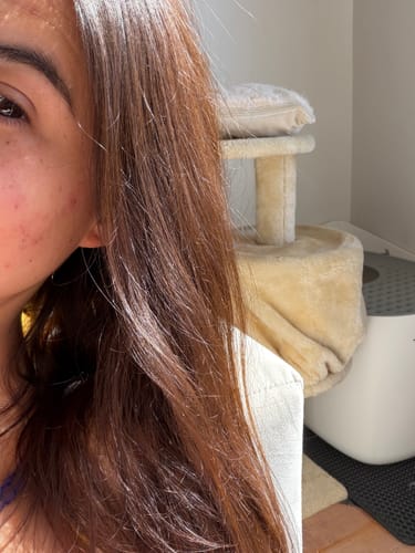 Clienta mostrando su cabello castaño y brillante después de usar el Pack Castaño Dorado.