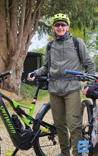 Reviewer standing outdoors with a mountain bike, wearing the Burnt Olive Tyrant Trail Trousers.