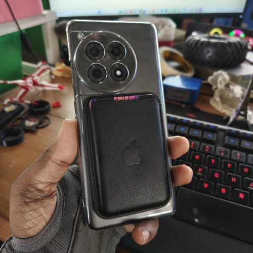 Reviewer showing the back of the Anti Yellow Magsafe Clear Case on a phone with a black magnetic wallet attached.