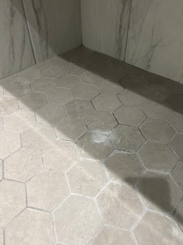 Customer's shower tile with white water softener buildup before using the Bathroom Concentrate.