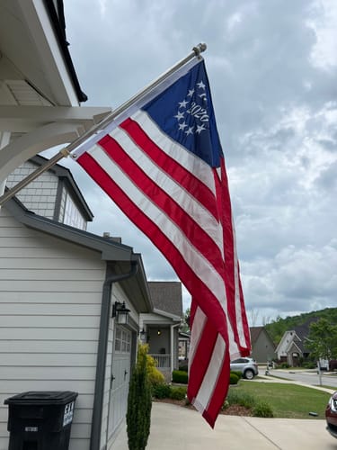 Customer's 1776 to 2026 Betsy Ross Flag hanging from a flagpole attached to the side of a house.