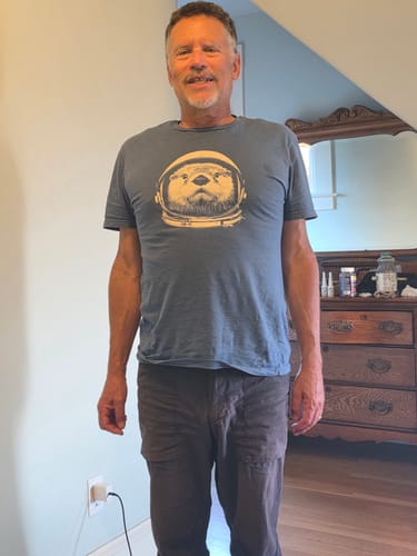 Reviewer standing and wearing the blue Otterspace t-shirt with its otter astronaut graphic.