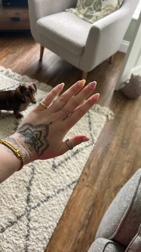 Customer showing the silver-colored Eloise Birthstone Ring on their tattooed hand.