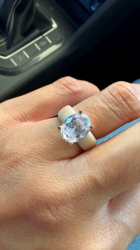 Customer's hand wearing the GlowStone Collection silicone ring, showing the sparkling oval-cut CZ stone.