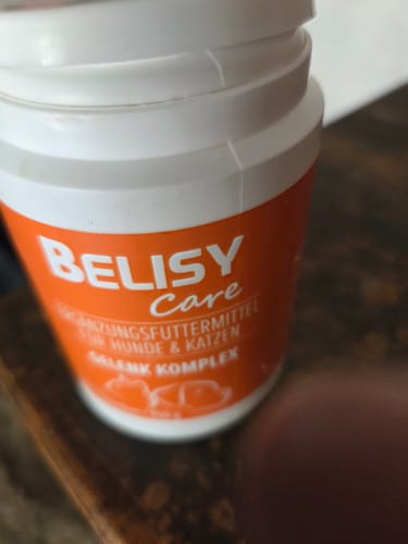 Rezensent zeigt eine Nahaufnahme der weiß-orangen Dose des Gelenk Komplex.
