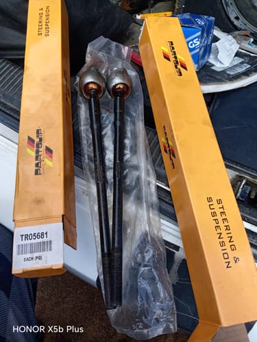Customer's two new Inner Rack Ends in plastic packaging, shown between their orange steering & suspension boxes.