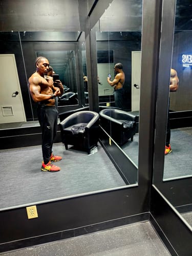 Customer flexing a muscular physique in a mirrored room, showing results from using Win-Test™.