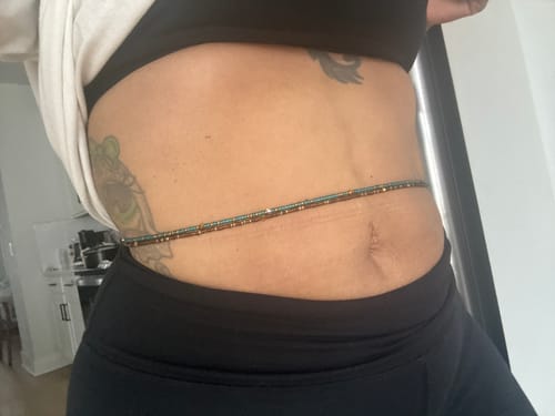 Reviewer showing the green and gold Eternal Green Tie On Waist Beads worn around their midsection.