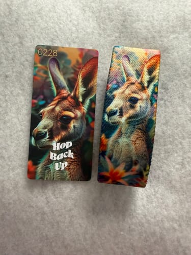 Customer's ZOX bracelet with a colorful kangaroo design, shown with its matching collector's card reading 'Hop Back Up'.