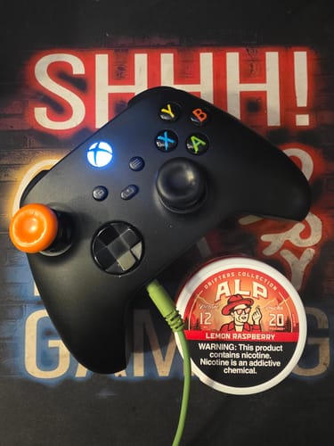 Customer's can of Drifters Lemon Raspberry Nicotine Pouches sitting next to a black gaming controller.