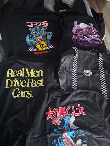 Customer's haul from the Cultimate Mystery Cash Box, including several graphic shirts, a hoodie, a bag, and a hat.