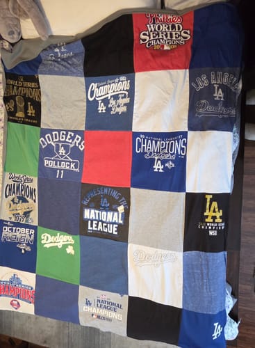 Customer's Project Repat T-Shirt Quilt made from various LA Dodgers championship t-shirts, laid out on a bed.