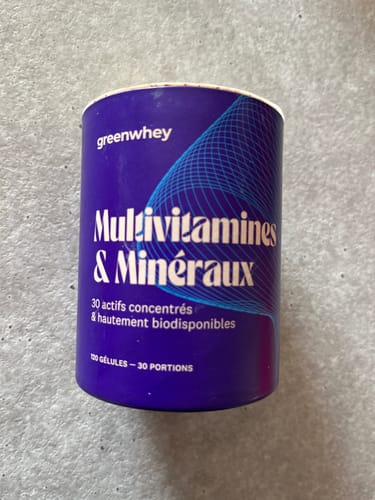Client présentant le pot de Multivitamines & Minéraux sur une surface claire.