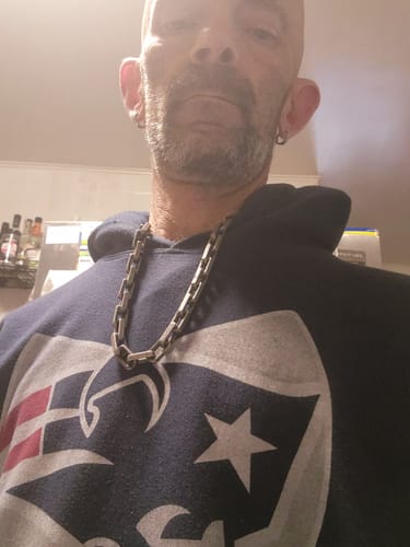 Close-up of the reviewer wearing the Invictus Unconquered Square Link Necklace over a hoodie.