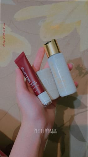 Customer's hand holding the white bottle of Peptide Milk Toner with other products from the order.