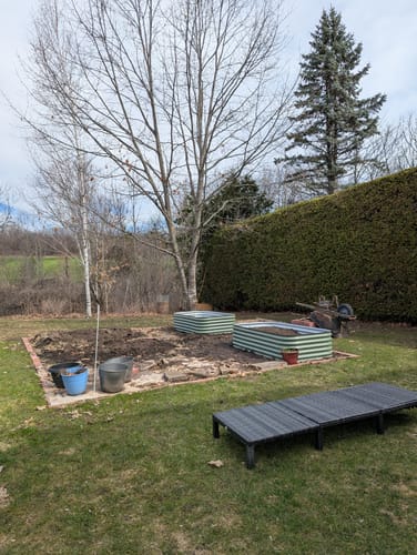 Customer's two assembled 17” Tall Modular 9 in 1 beds filled with soil in a backyard garden plot.