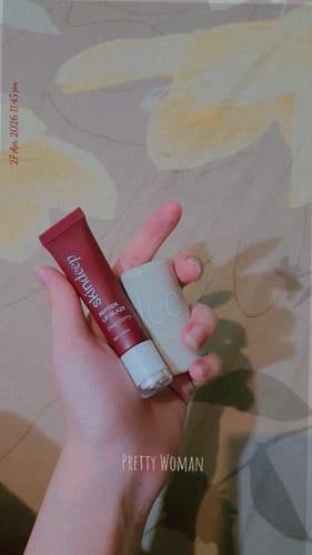 Customer's hand holding a Skindeep lip glaze and bar from the order that included the Peptide Milk Toner.