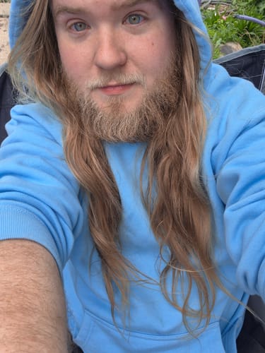 Reviewer wearing the bright blue DCG87 Hoodie with the hood up.