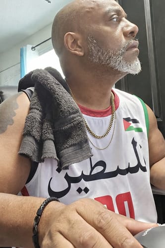 A close-up of a reviewer wearing the white Palestine Custom Basketball Jersey with a towel over their shoulder.