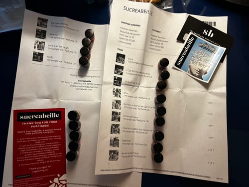 Customer displays their perfume oil samples, including 'No Power in the 'Verse Can Stop Me', on top of their order invoice.